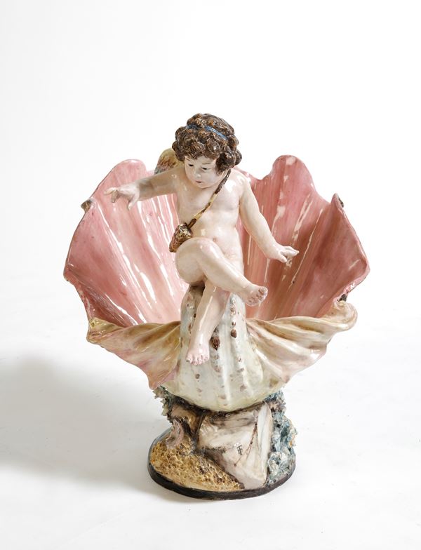 Centrotavola in ceramica policroma a foggia di conchiglia e putto