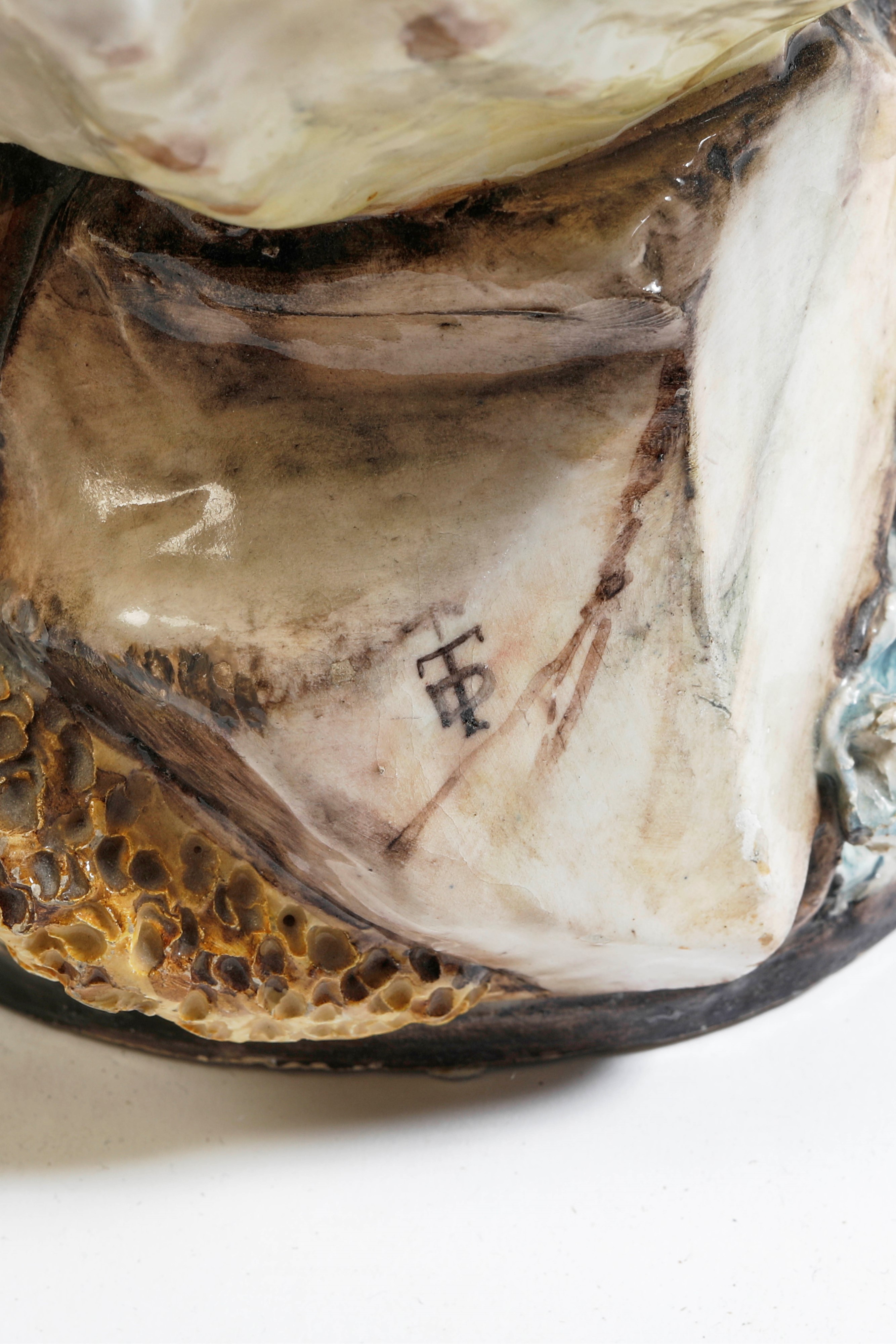 Centrotavola in ceramica policroma a foggia di conchiglia e putto